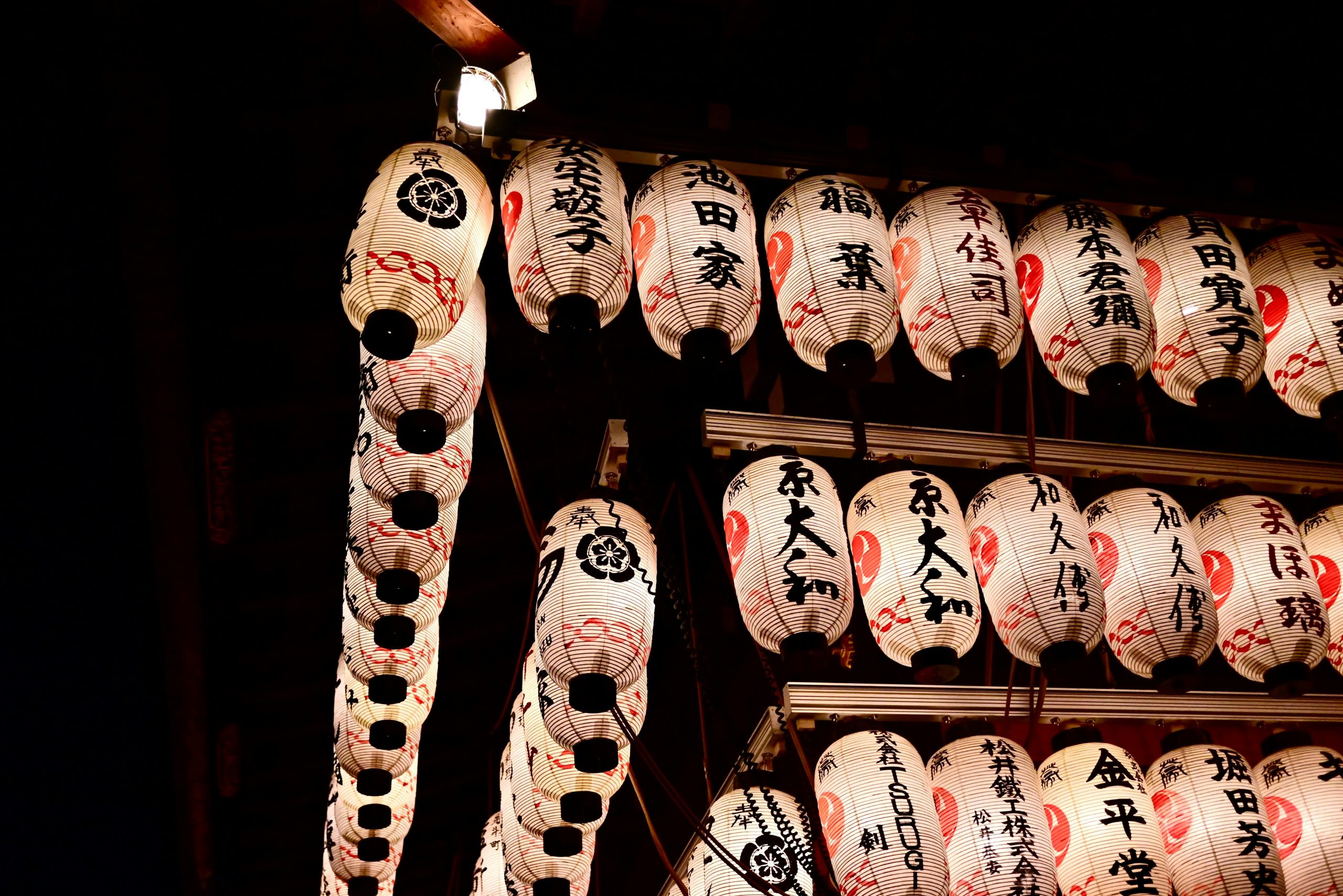 A captivating display of illuminated traditional Japanese lanterns at night, showcasing cultural artistry.