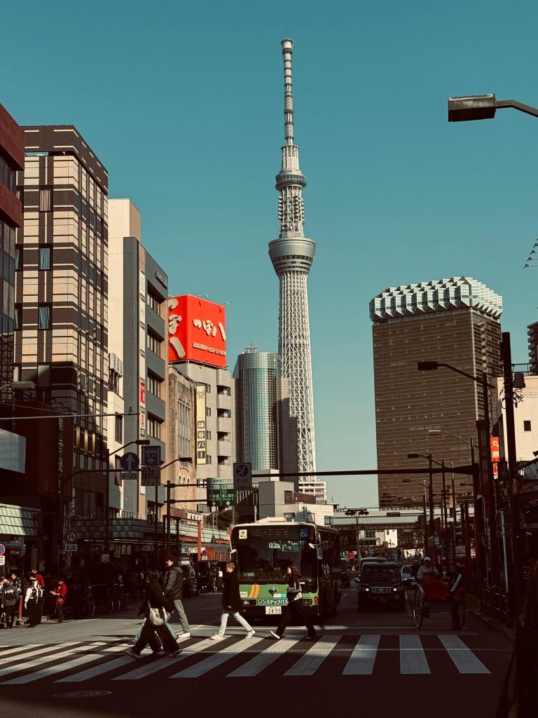 A bustling street scene in Tokyo with the iconic Skytree tower and vibrant urban life.